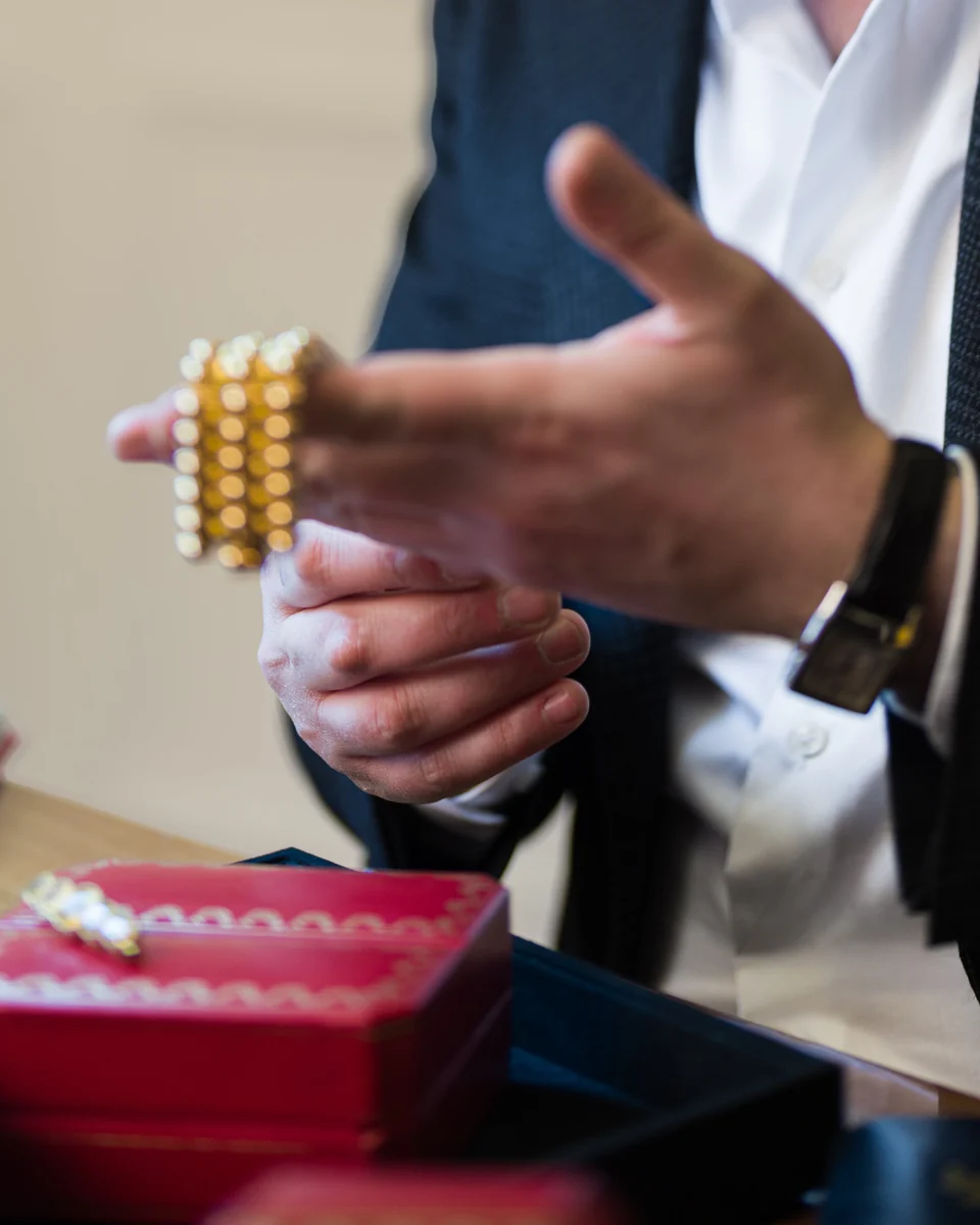 Un bracelet en or présenté à la main, au-dessus des écrins, 22 rue Drouot