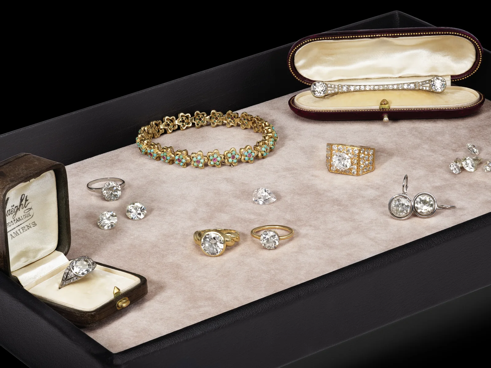 Un plateau de la maison : bagues et diamants taille ancienne, bracelet en or, turquoises et rubis, broche barrette dans son écrin, dormeuses