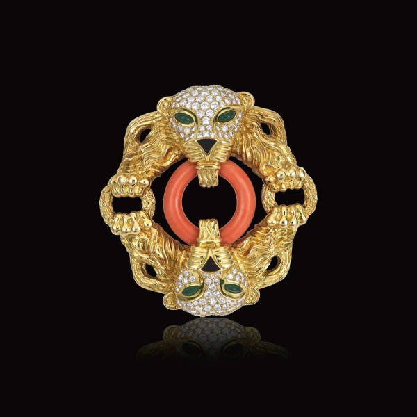 Broche aux lions en or ciselé, sertis de diamants, yeux d'émeraude, anneau de corail